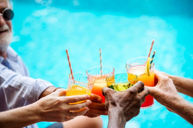 Closeup of diverse hands clinking drinks together