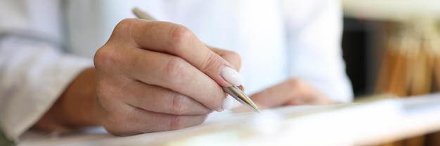 Closeup of doctor in medical gown put sign on clipboard with documents qualified worker made