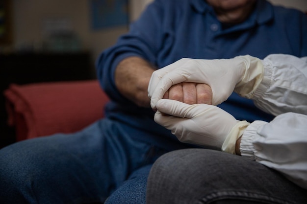 Closeup of a doctor's hands holding the hands of an elderly patient