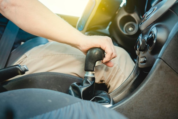 車のギアレバー上のドライバーの手のクローズアップ 車のギアスティックをつかむドライバーの手 ギアスティックで加速する手のクローズアップ