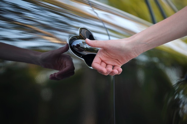 Closeup of driver hand opening car front door with touch id\
finger imprint scanning technology vehicle safety concept