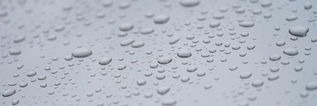 Closeup of drops on dark glass car background