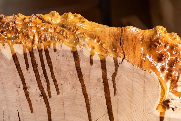 Крупным планом капли эпоксидной смолы текут по деревянному столу