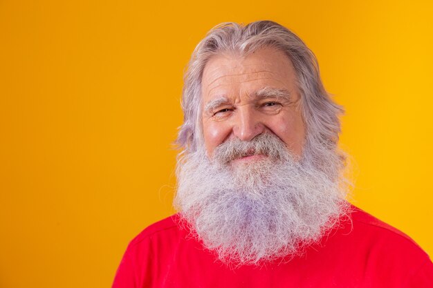 Closeup of an elderly Caucasian bearded man on yellow background.