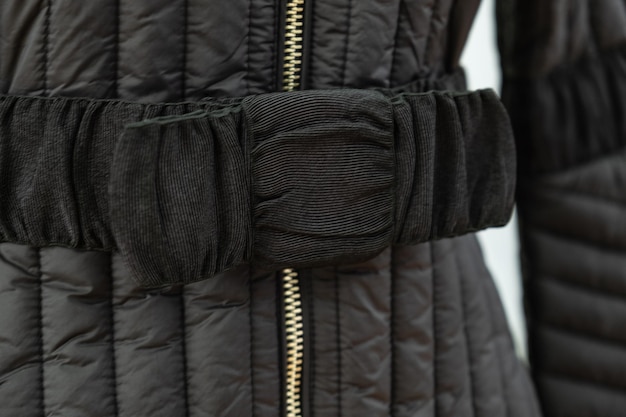 Photo closeup of an elegant belt on a quilted womens autumn coat elegant womens clothing coat details