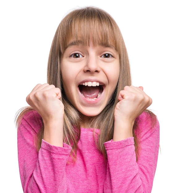 Closeup emotional portrait of attractive caucasian girl looking at camera and smiling Beautiful happy child isolated on white background Lucky cheerful schoolgirl celebrating triumph