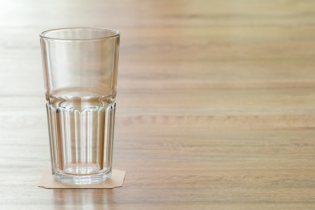 Photo closeup empty glass on wooden table, meaning a positive attitude towards something and prompt to learn anything