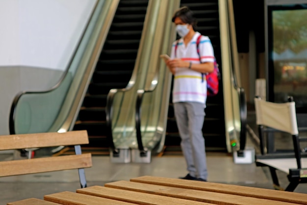 Closeup empty wooden table with blurry man wearing face mask protects against flu