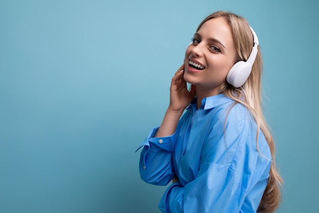 Closeup of a european girl in wireless large headphones in a casual outfit enjoys and relaxes to the