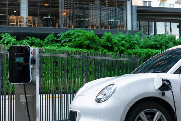 Photo closeup ev car and charger with blur background for progressive concept