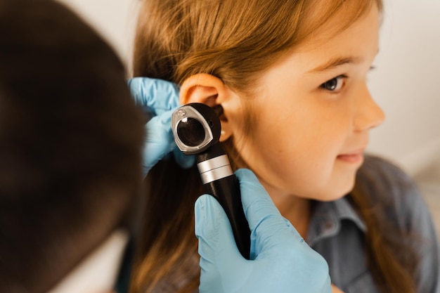Фото Осмотр уха ребенка крупным планом с помощью отоскопа отоскопия посещение лор-врача и консультация