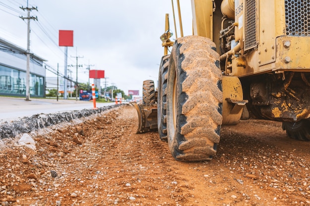 Foto escavatori del primo piano che rimuovono la pietra nei lavori di costruzione di una strada e di riparazione