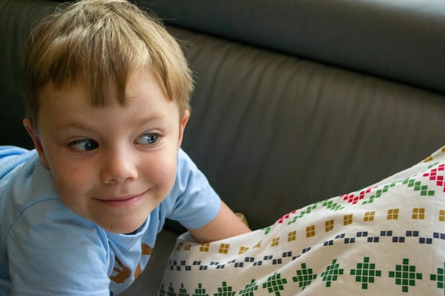 Closeup of the face of a beautiful year old boy lying on the bed high quality photo