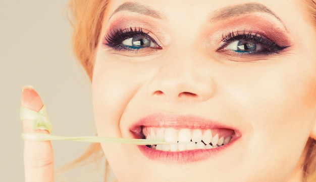 Foto primo piano viso sorriso donna trucco gomma da masticare bubble gum da masticare ragazza ritratto di gomma da masticare femmina divertente e felice trucco bellezza e trucco degli occhi