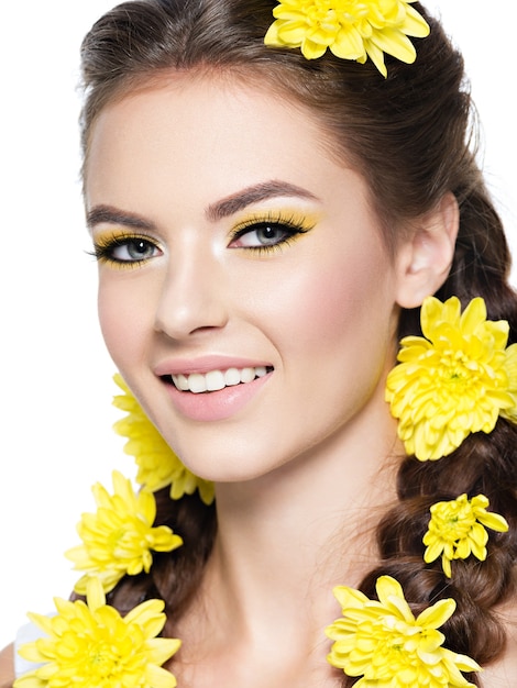 Closeup face of an young smiling beautiful woman with bright yellow makeup fashion portrait