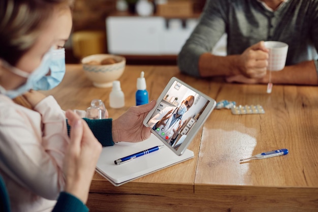 Closeup of family having video call with their doctor at home due to covid19 pandemic