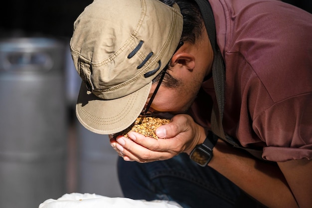 아시아 양조장에서 밀알을 들고 있는 농부의 수제 양조업자의 손을 클로즈업