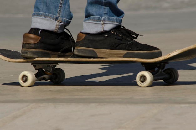 closeup of feet with sneakers on skateboard deck