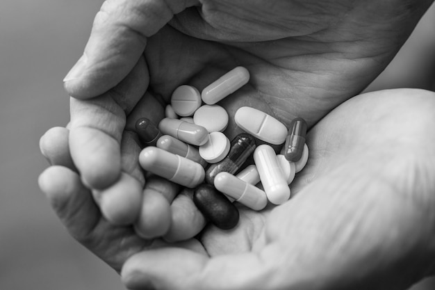 Closeup female adult hands holding a lot of pills