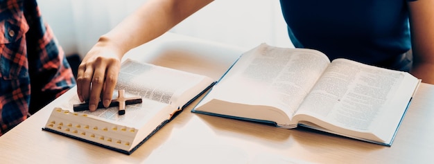 Photo closeup female christian prayer pickup holy cross on bible book burgeoning