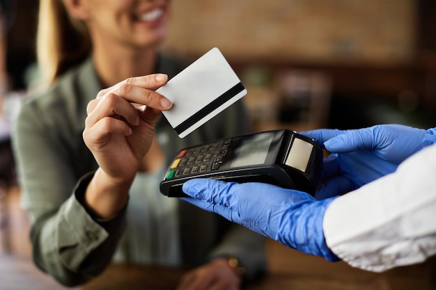 Primo piano del cliente femminile che effettua il pagamento contactless in un caffè