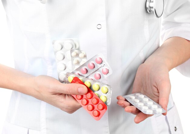 Closeup of female doctor hand holding pills isolated on white