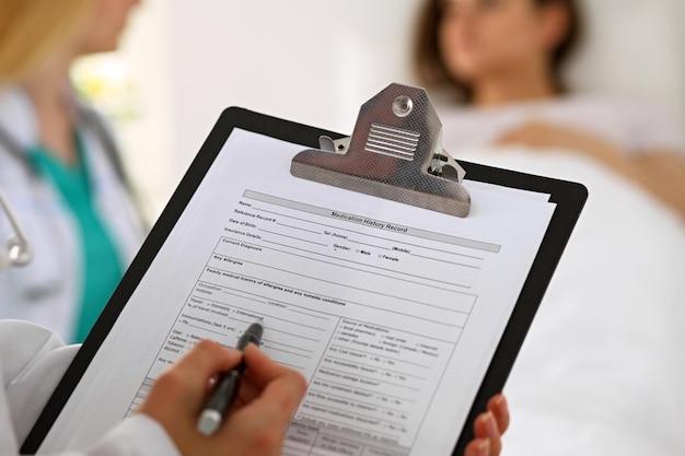 Closeup of a female doctor while filling up medical history record