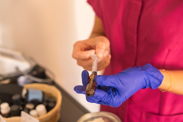 Closeup of a female doctor with blue latex gloves and uniform preparing the flu vaccine