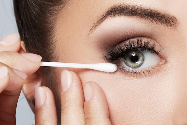 Closeup of female face with a cotton swab beside beautiful eye