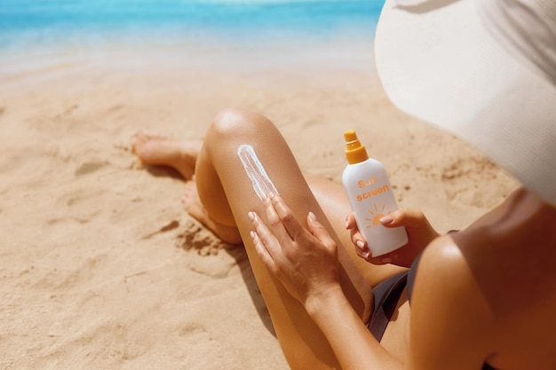 Closeup on female Hand applying solar sun cream on Leg Skincare Sun protection