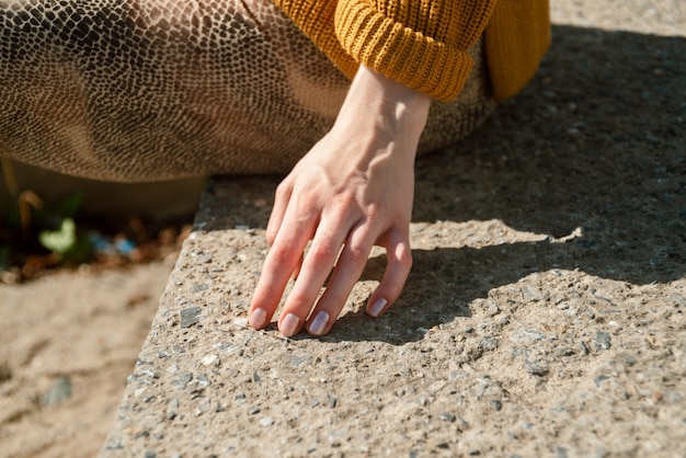 Closeup of female hand touching stone stairs outdoors