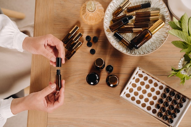 Foto primo piano delle mani femminili che tengono una bottiglia di aromaterapia dell'olio essenziale