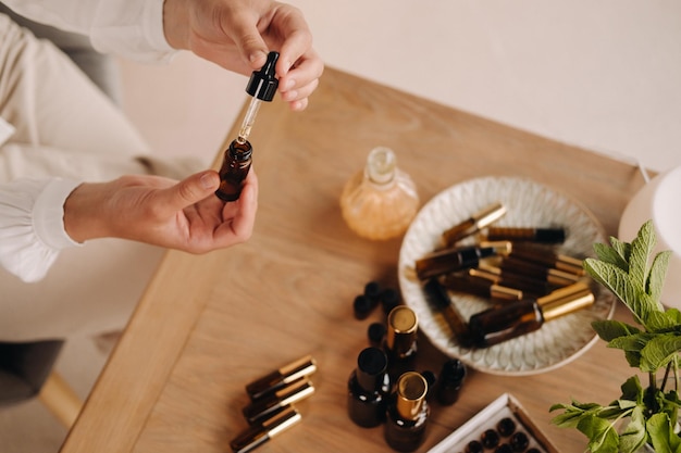 Photo closeup of female hands holding a bottle of essential oil aromatherapy