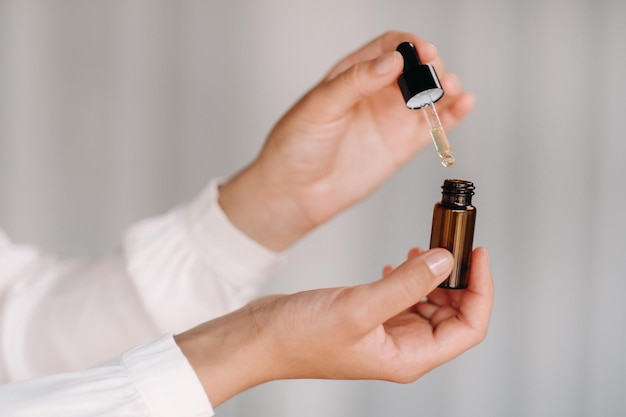 closeup of female hands holding a bottle of essential oil aromatherapy