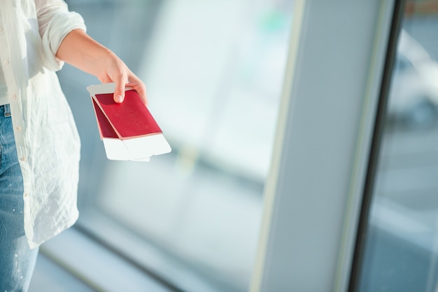 Closeup of female hands holding passports and boarding pass at airport