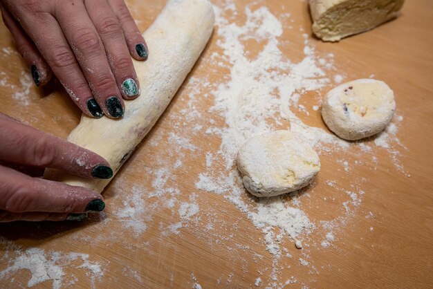 Foto primo piano delle mani femminili che srotolano la pasta dolce per la cottura