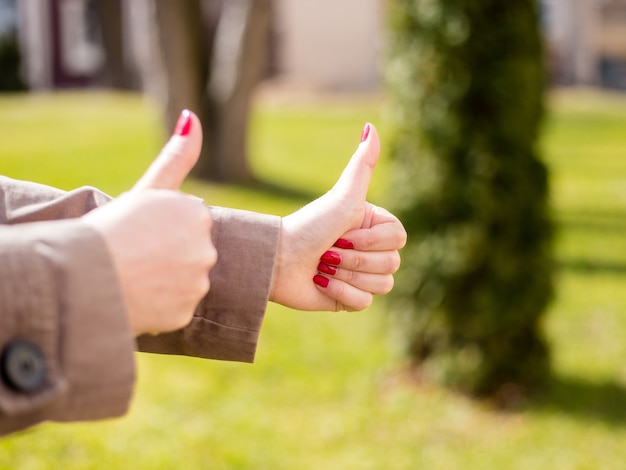 Closeup of female hands showing thumb up sign