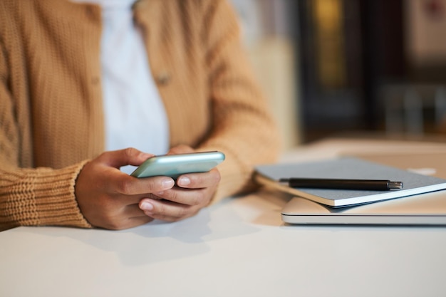 Closeup female hands using modern smartphone checking social media content testing new mobile app