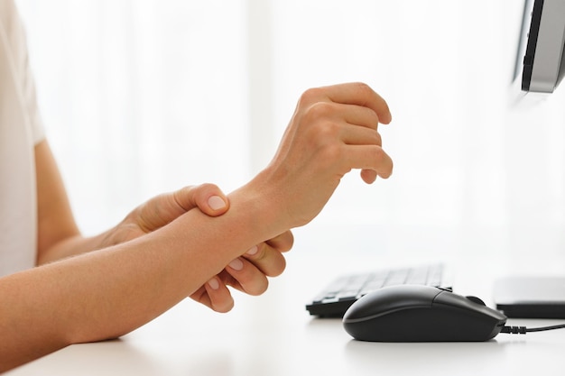 Closeup of female hands with a pain in the wrist because of carpal tunnel syndrome