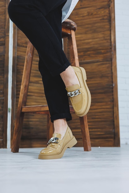 Closeup of female legs in black jeans in stylish leather beige shoes Fashionable woman in new loafers Modern seasonal collection of stylish shoes Womens fashion