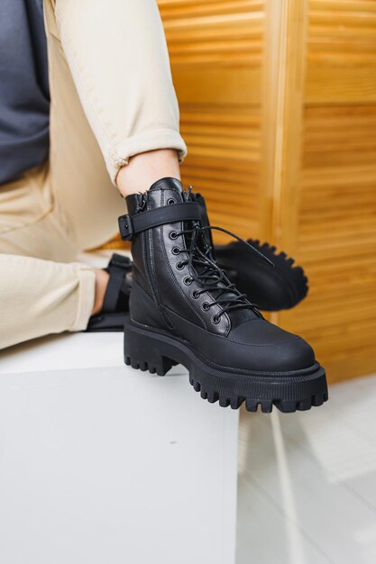 Closeup of female legs in black leather laceup boots Women's winter shoes New autumn collection of women's leather shoes