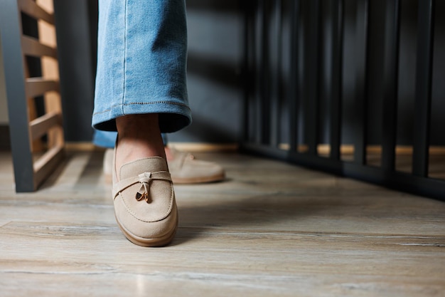 Closeup of female legs in jeans and beige loafers made of genuine leather