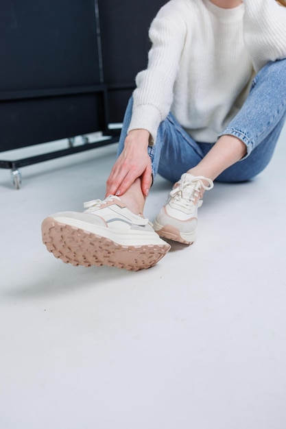 closeup of female legs in jeans and casual sneakers women's comfortable casual shoes white leather women's sneakers