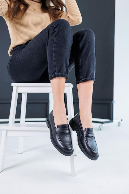 Closeup of female legs in pants and black leather classic chelsea shoes Women's comfortable summer shoes New springsummer collection of women's leather shoes 2023