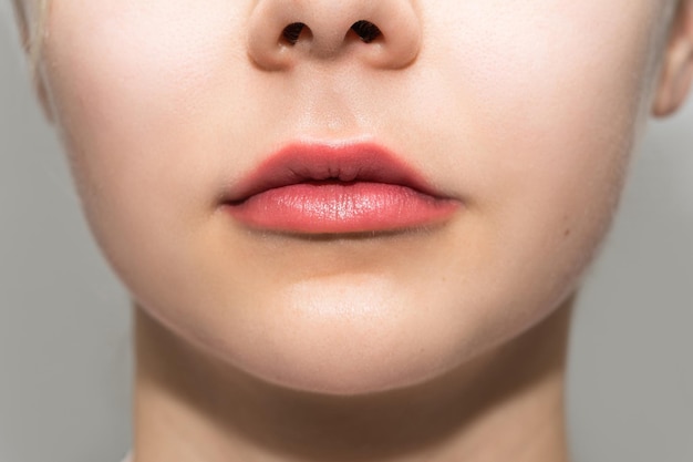 Closeup of female lips after permanent makeup lip blushing procedure