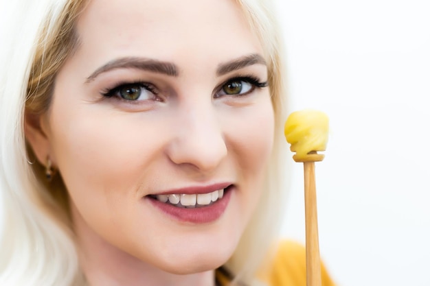 Photo closeup of female mouth and spoon with honey on white background