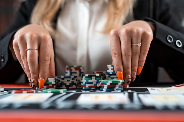 closeup female player are taking chips from the poker table at casino Gambling concept risk for win