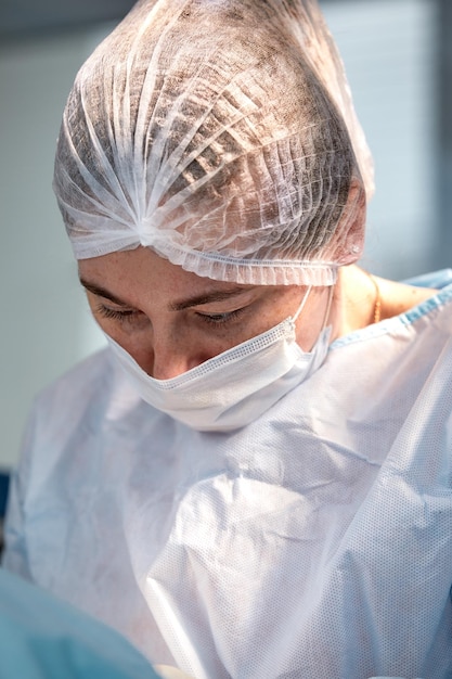 Primo piano di un chirurgo femminile in una sala operatoria un medico con un'espressione tesa sul viso in una sala operatoria