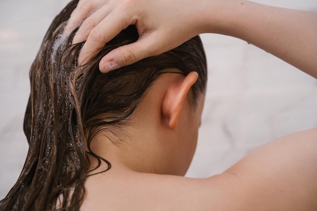 Foto primo piano della femmina che si lava i capelli