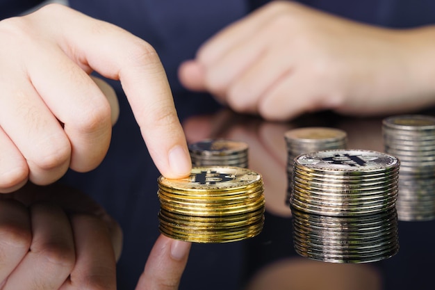 Closeup of finger touching golden bitcoin coin